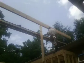 Carpenter setting a ridge beam over a new addition frame — Ice Dam Removal by Roofing Brothers in Cougar